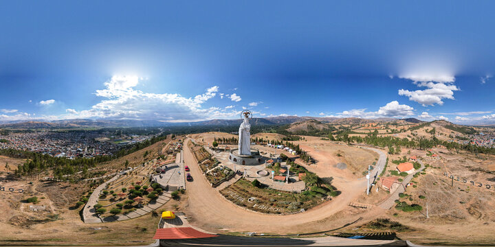 Aerial view of the Virgen de la Concepcion statue standing on a hill overlooking the town with surrounding dry landscape and clear blue sky in Concepcion, Junin, Peru.
