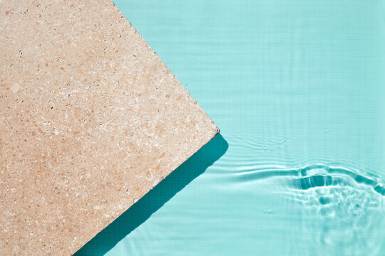 Travertine coping with turquoise swimming pool water surface