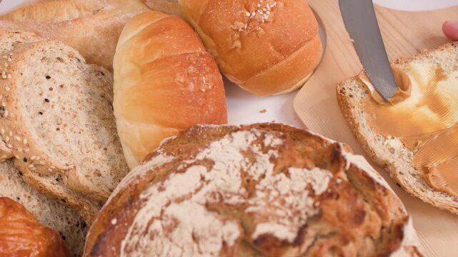 Spreading Creamy Peanut Butter on Multigrain Bread with Assorted Loaves