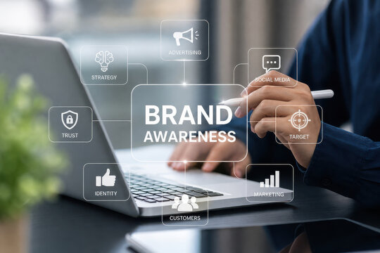 Brand awareness concept with businessman using laptop and stylus, marketing strategy icons overlay conveying advertising, social media, target, trust and customer engagement