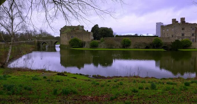 Wide establishing shot of Leeds Castle surrounded by its historic moat and landscaped grounds in Kent, England.