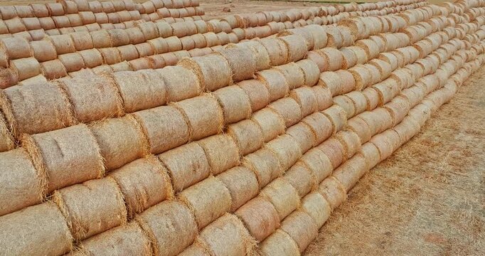 Large stack of round hay bales on farmland for agriculture livestock feed storage