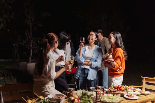 Group of friends enjoying outdoor night barbecue dinner party
