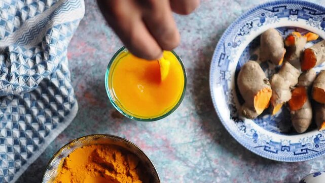 Mixing turmeric with water and preparing herbal drink