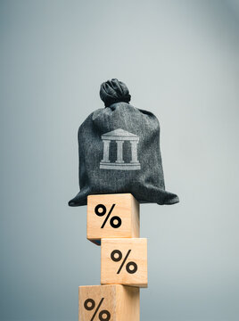 Banking risk and interest rate risk concept featuring a bank asset symbol balanced on percentage blocks. Monetary policy, deposit risk, financial stability, banking crisis, and economic uncertainty.