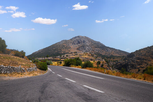 Road winding through Peloponnesos landscape under blue sky