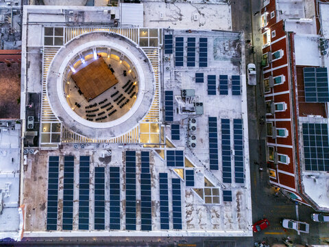 Aerial view of a modern building rooftop featuring a circular courtyard and extensive solar panel arrays in Merida, Yucatan, Mexico.