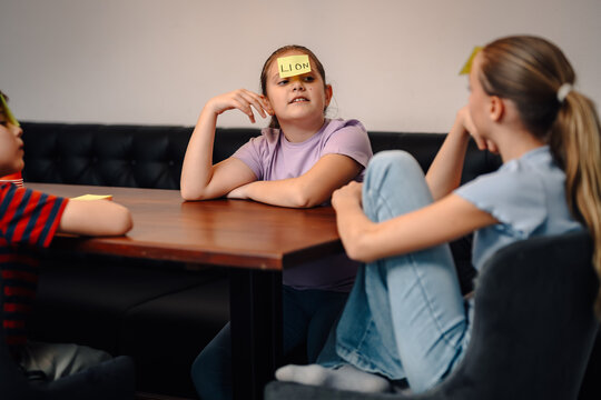 Children playing guessing game with sticky notes
