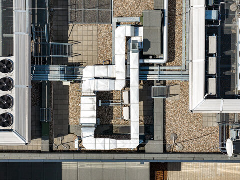 Aerial view of an advanced AI datacenter rooftop featuring complex ventilation ducts, industrial HVAC systems, and gravel surfaces in Warsaw, Masovian Voivodeship, Poland.