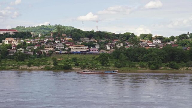 Cargo Ship Navigating the Mekong River with Huay Xai Laos in Background 4k video footage