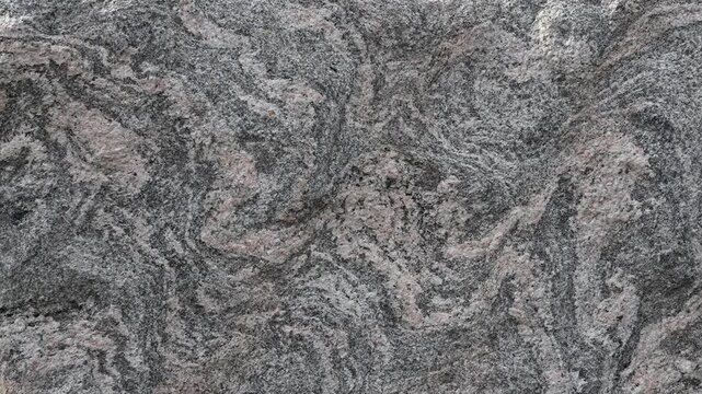 Close-up of natural granite rock surface with swirling patterns