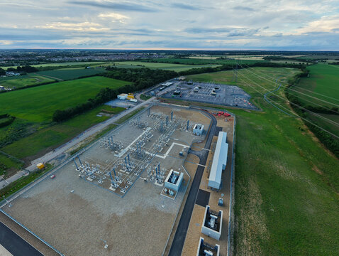 Aerial view of Biggleswade National Grid 400132kV Substation featuring electrical infrastructure and switchgear in green fields in Biggleswade, England, United Kingdom.