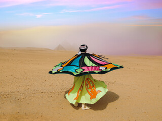 Fototapeta premium Whirling dervish dancer mid spin twirling a colorful tanoura skirt in the Egyptian desert before the Giza pyramids under a pastel sky ideal for
