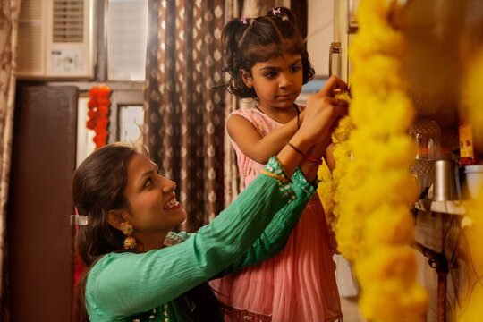 Mother and daughter decorating home with flowers.