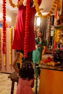 Family decorating kitchen with colorful garlands.