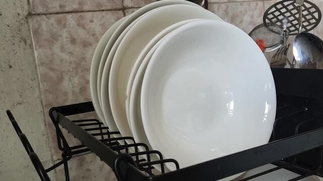Clean dishes on a drying rack in modern kitchen, household chores, hygiene, cleanliness and home organization concept.