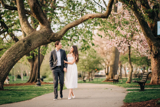 Couple walking arm in arm enjoying spring park date