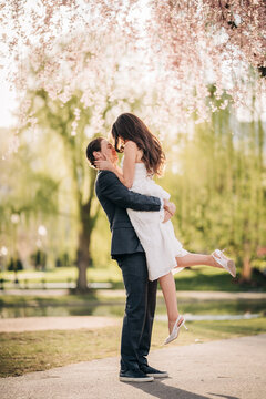 Loving couple embracing in romantic cherry blossom park