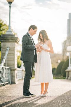 Couple proposing marriage with engagement ring on bridge