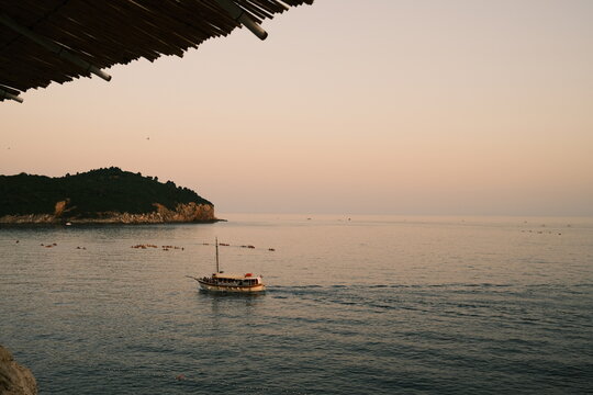 Boat Sailing past a Rocky Island View from a Bamboo Canopy