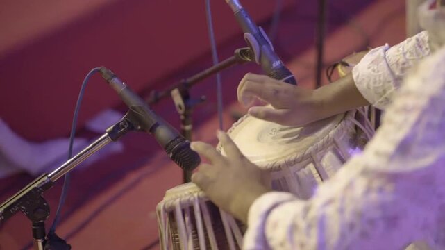 Tabla Player Performing Live on Stage,Traditional Tabla Performance Close Up,Indian Percussion Music Concert,Musician Playing Tabla with Microphones stock video.



