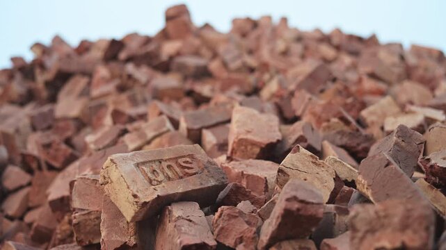 Shallow depth of field shot of a massive hill of broken clay bricks at a Dhaka, Bangladesh factory. Documents structural debris, material wastage, and third world infrastructure trade.