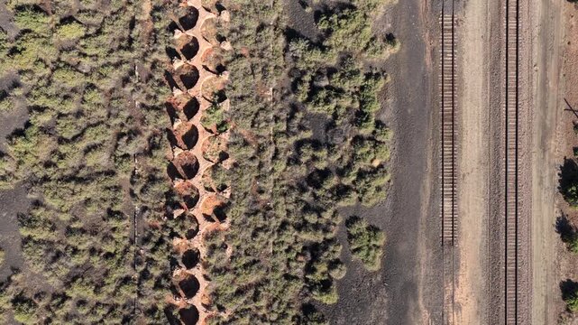 4K UHD straight-down drone perspective of the historic Waldo ghost town ovens. The distinct repeating pattern of circular pits creates a unique visual of old western remains.