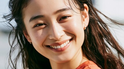 Fototapeta premium Smiling young Japanese woman with wind in her hair