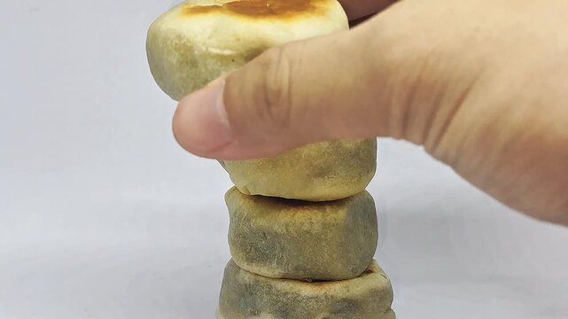 Hand taking a bakpia from stack