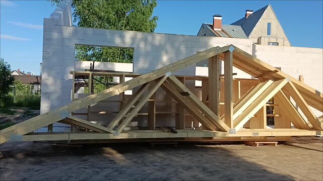 Wooden roof trusses at a house construction site. Building cottage from aerated concrete blocks. Real estate development. Prefab building.