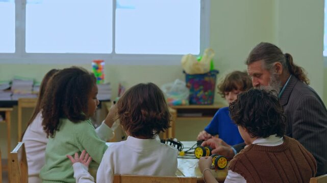 Classroom child teacher robot education learning student science technology workshop group building wheeled machine school activity guided creative discussion indoor lesson