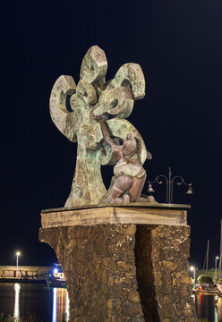  Riposto,  Italy August 15, 2025 monument to fallen seafarers illuminated at harbor in Riposto, Catania