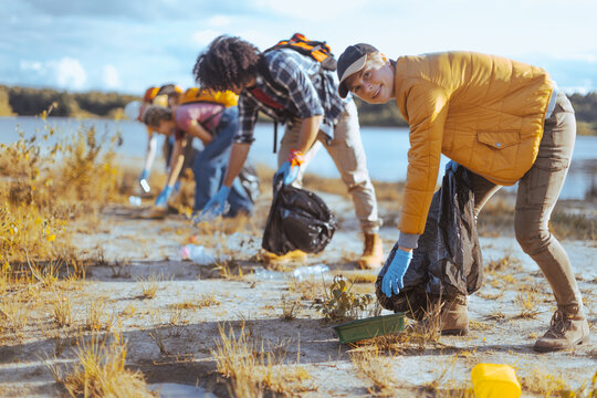 Group of volunteers cleaning up lake environment from trash