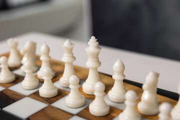 The chessboard contains white pieces: pawns, a knight, a bishop, and a rook. Selective focus on the white pieces. © Natalya Likhina