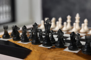 There are black pieces on the chessboard: pawns, a knight, a bishop, and a rook. Selective focus on the black pieces. © Natalya Likhina