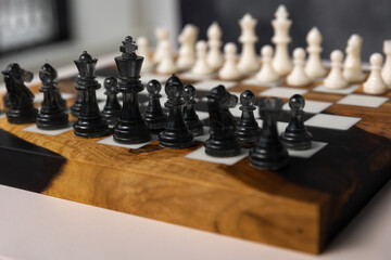 There are black pieces on the chessboard: pawns, a knight, a bishop, and a rook. Selective focus on the black pieces. © Natalya Likhina