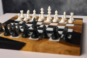 Chessboard featuring a complete set of white and black chess pieces arranged and ready for a game. © Natalya Likhina