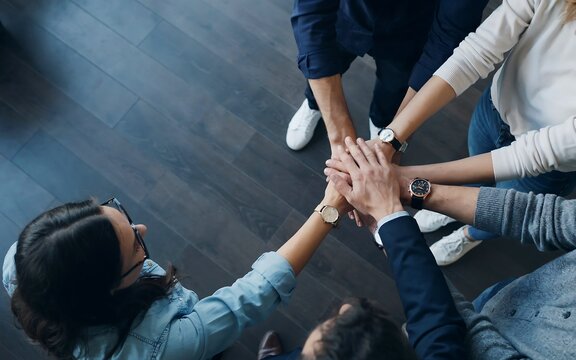 Diverse business team stacking hands for unity and teamwork
