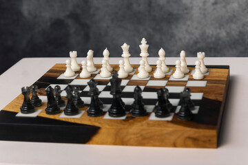 Chessboard featuring a complete set of white and black chess pieces arranged and ready for a game. © Natalya Likhina