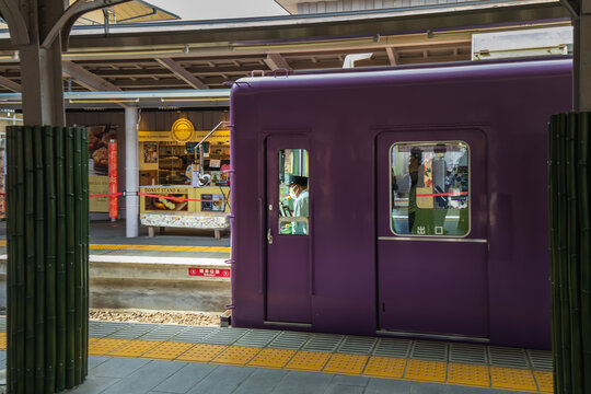 Kyoto, Japan April 18, 2026 train stopped at arashiyama station platform with staff and passengers visible
