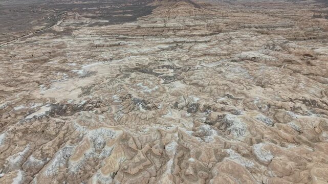 Aerial drone footage of the colorful Aktau Mountains in Altyn Emel National Park, Kazakhstan. Dramatic desert landscape with striped clay hills, rocky formations and scenic travel destination atmosphe