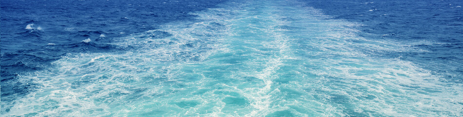 Obraz premium Foam water trail behind the ferry. View from the ship to the sea