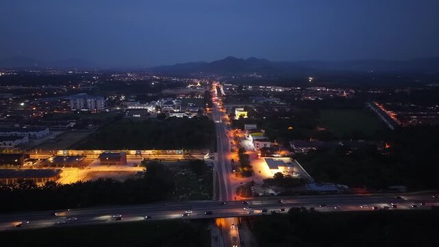 Night aerial footage showing car traffic on a main road and highway in Jawi, Penang, Malaysia.