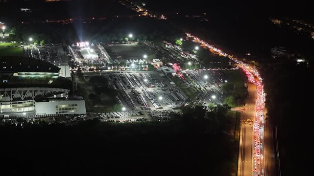 Aerial night footage of Batu Kawan Modifighter Festival parking area and congested roadway.
