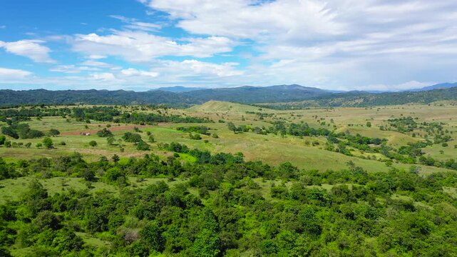 Summer tropical landscape. Green hills and mountains with tropical vegetation and blue sky with clouds. Philippines, Luzon. Summer landscape.