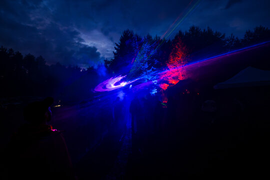 Spectacular laser light show at outdoor music festival in the night forest