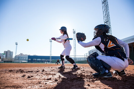 Female batter hitting the ball during a baseball game