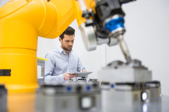 Young businessman checking automated production in factory