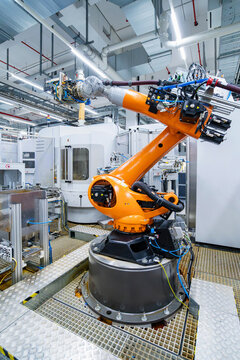 Orange industrial robot arm in automated manufacturing hall