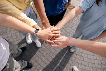 Obraz premium Diverse people uniting hands for teamwork and collaboration